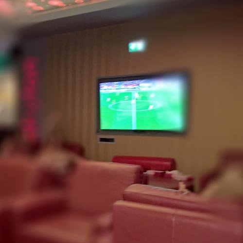 Ein Großbildschirm im hinteren Clubraum mit einer Fußballübertragung